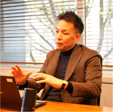 震災後の転機やサイネージ事業の挑戦について語るクラウドポイント常務・田中孝弥氏のインタビュー中の姿